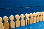 © Andrii Yalanskyi - stock.adobe.com Holzfiguren in einer Reihe, eine hat ein ausgeschnittenes Kind